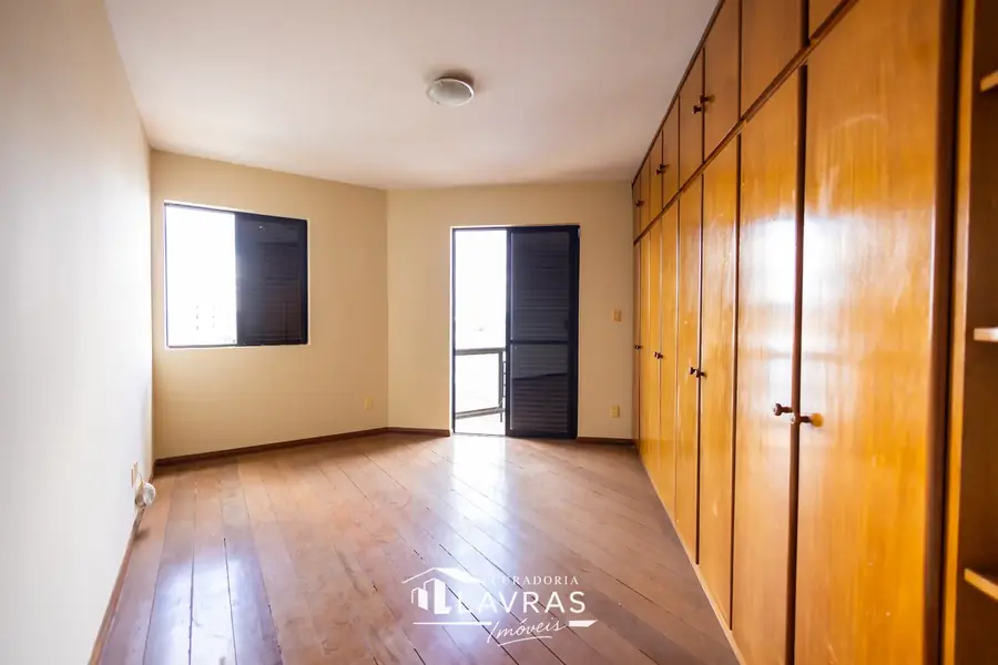 Quarto com armários em madeira e janela